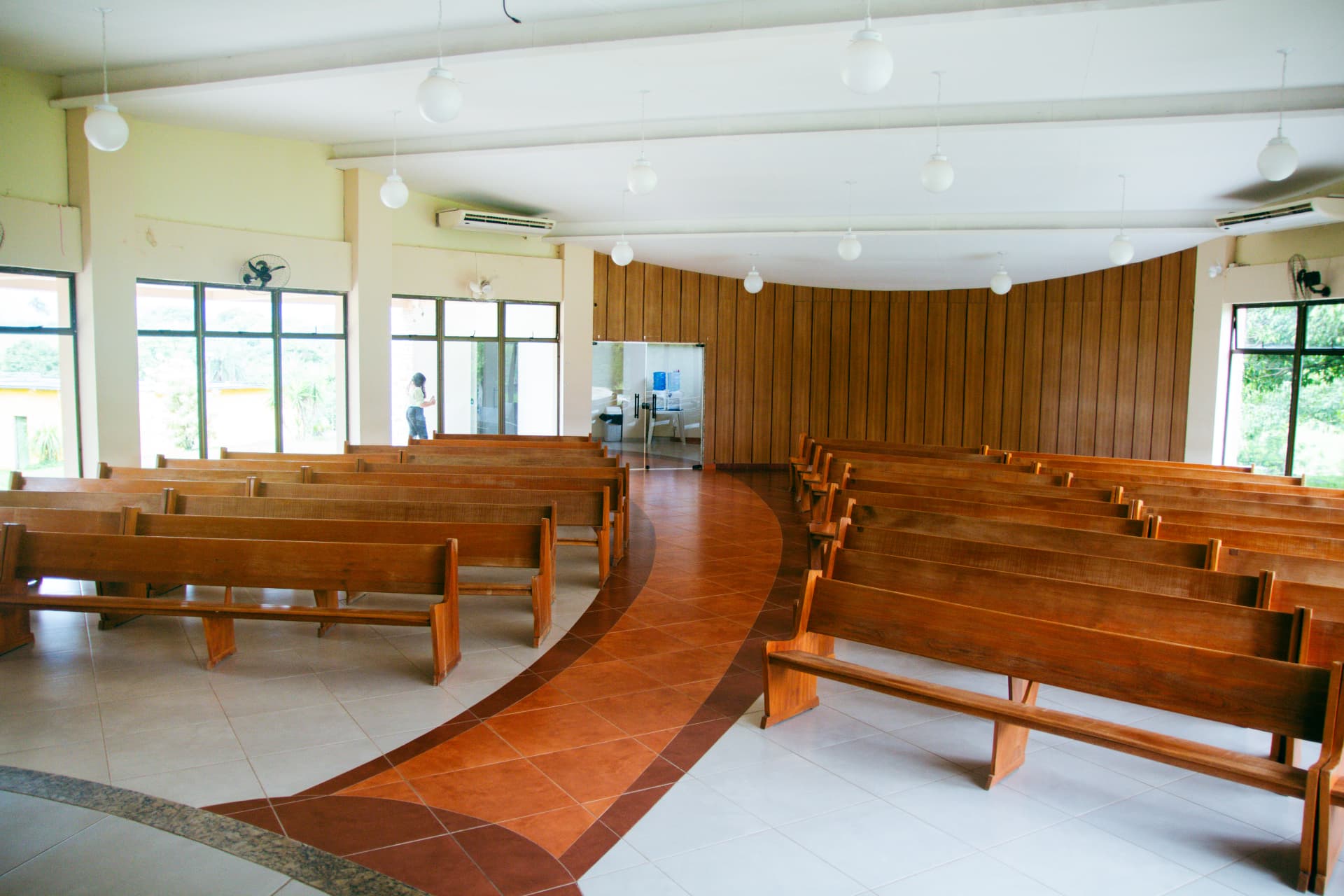 Interior da Casa de Oração com bancos de madeira