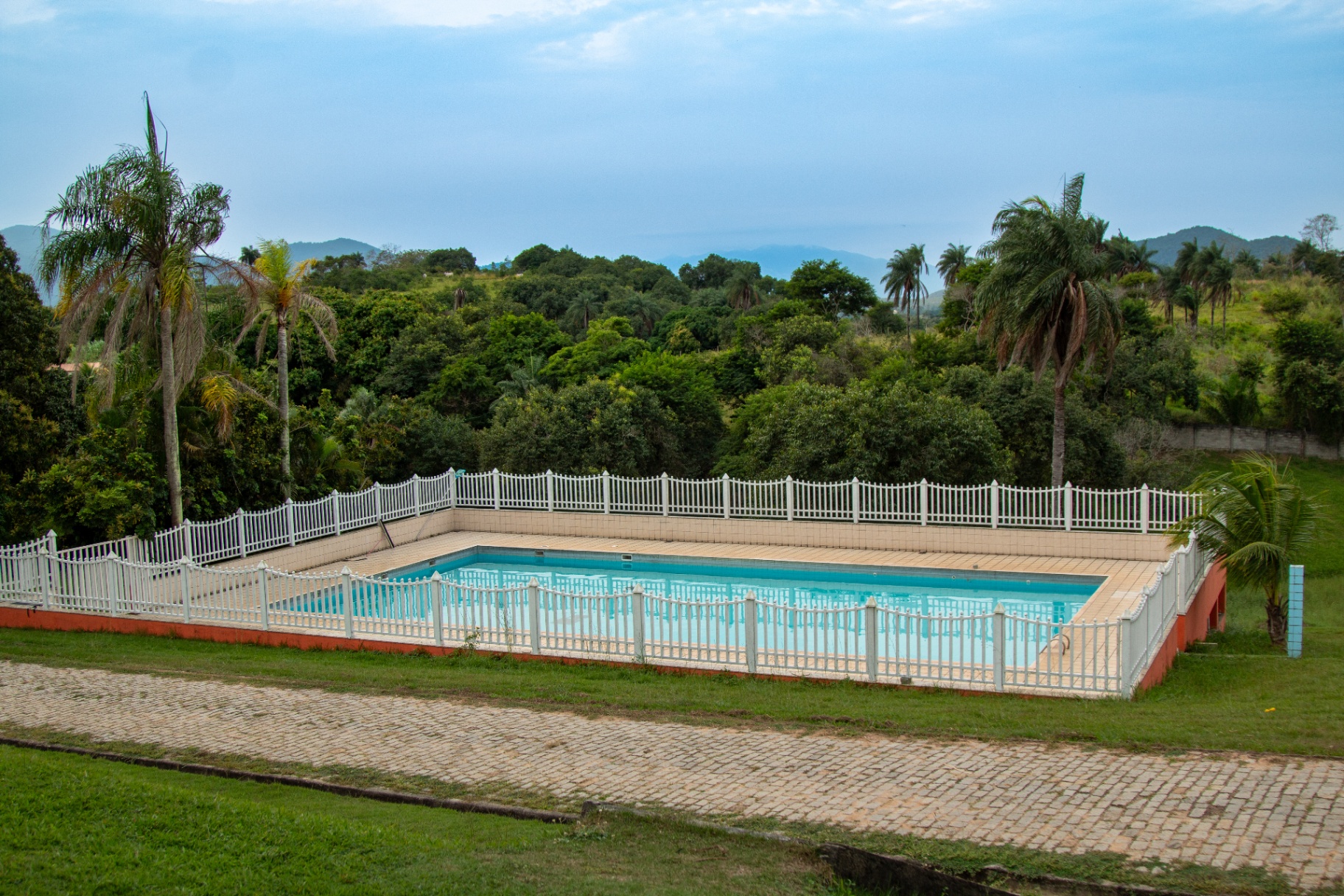 Piscina cercada com vista para a mata e as montanhas